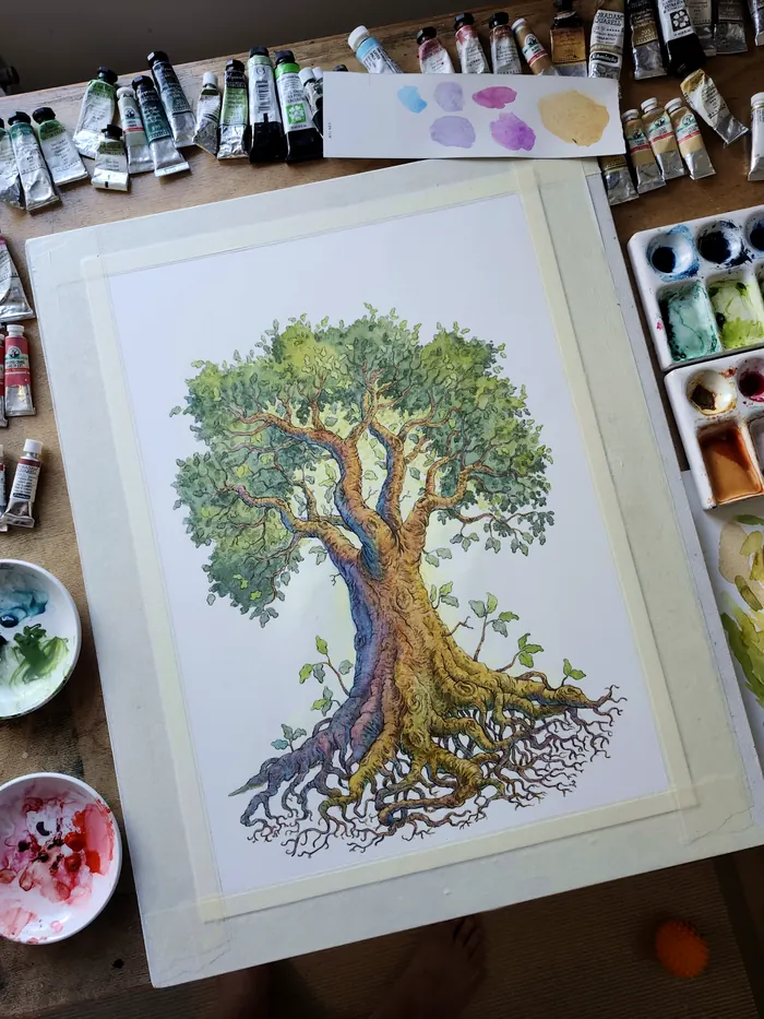 The Life Tree in watercolour on a work table with paint tubes and palette